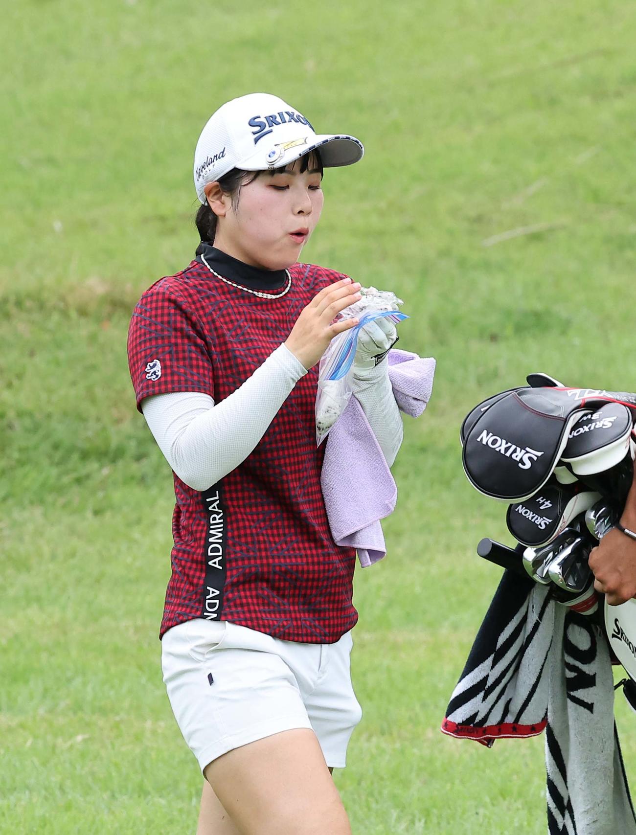 18番、最終ホールでおにぎりを食べる尾関彩美悠（撮影・上田博志）