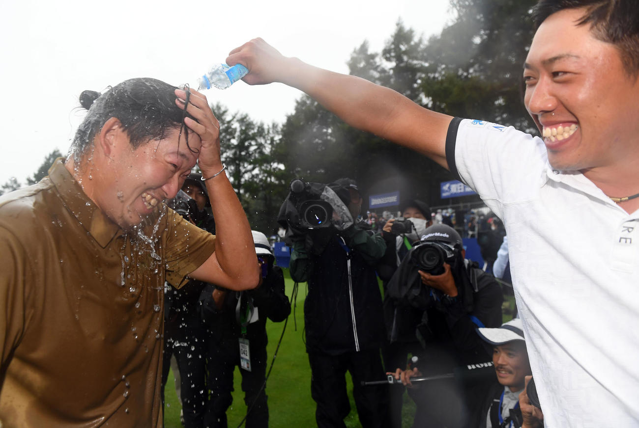 優勝を飾り堀川（右）から水をかけられる大槻（撮影・たえ見朱実）