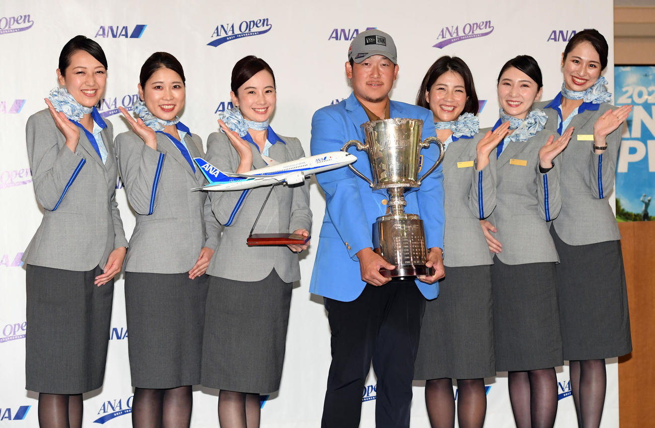 優勝を飾り、全日空のキャビンアテンダントと記念撮影に納まる大槻（撮影・たえ見朱実）