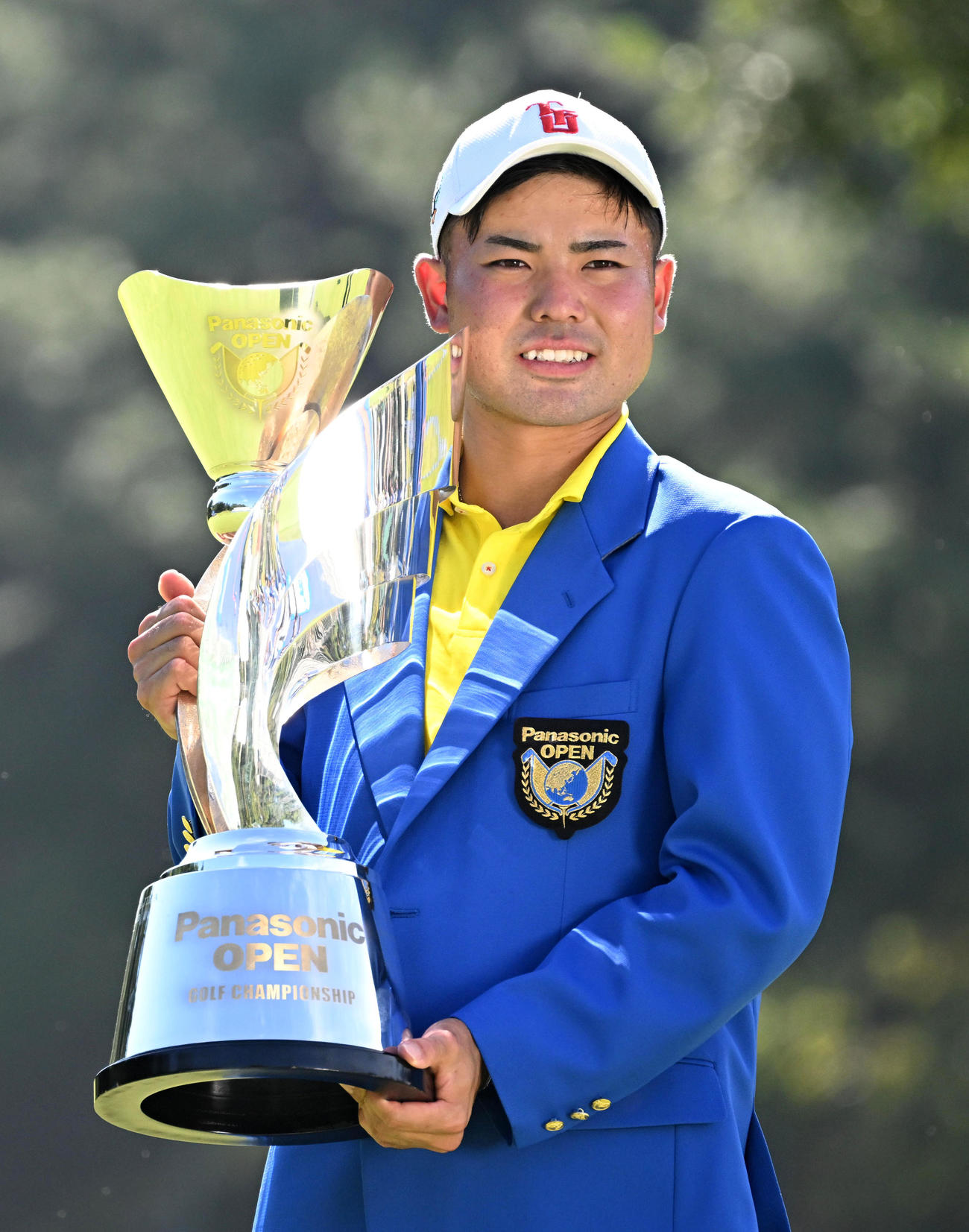 通算22アンダーで優勝、優勝トロフィーを手に笑顔を見せる蝉川（撮影・前岡正明）