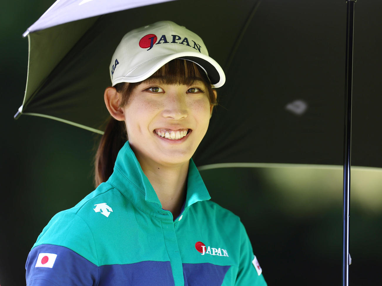 かさを手に笑顔で移動する馬場（撮影・足立雅史）