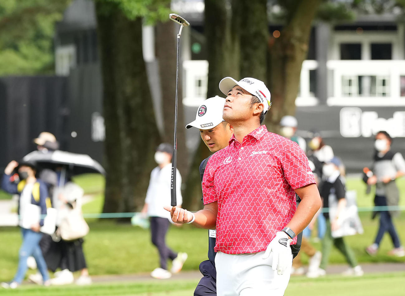 ギャラリーを引き連れ歩く松山はパターを指先に乗せリラックスした表情を見せる（撮影・垰建太）