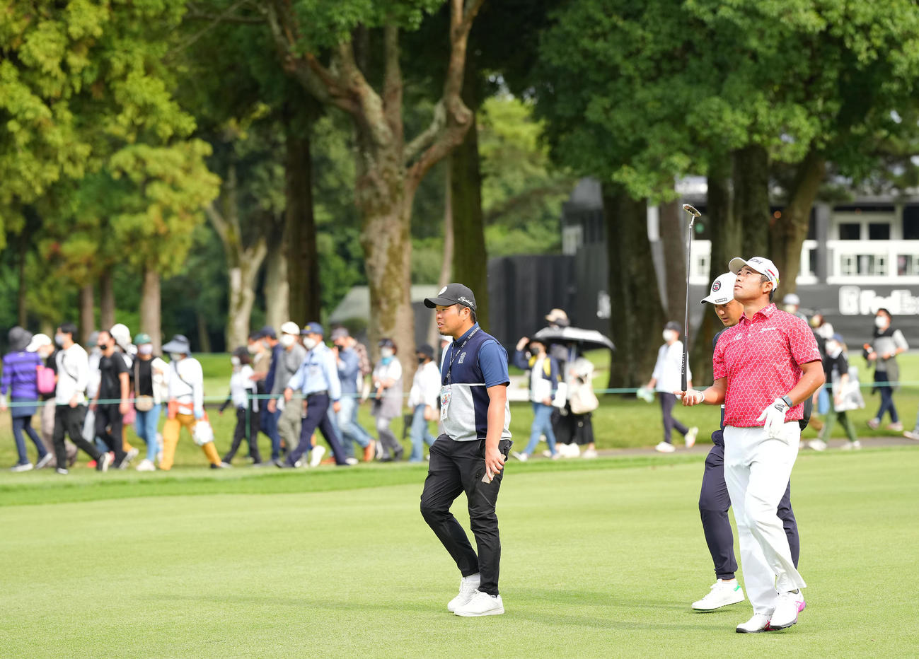 ギャラリーを引き連れ歩く松山はパターを指先に乗せリラックスした表情を見せる（撮影・垰建太）
