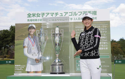 展示された全米女子アマチュアゴルフ選手権の優勝トロフィーと笑顔で写真に納まる馬場（撮影・前田充）