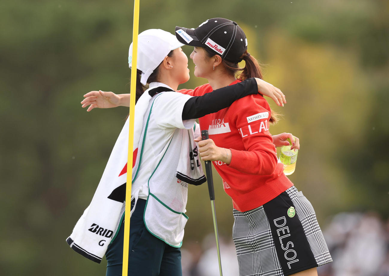 18番、ウイニングパットを沈め、キャディーを務めた森田彩聖さん（左）と抱き合って喜ぶ川崎（撮影・前田充）