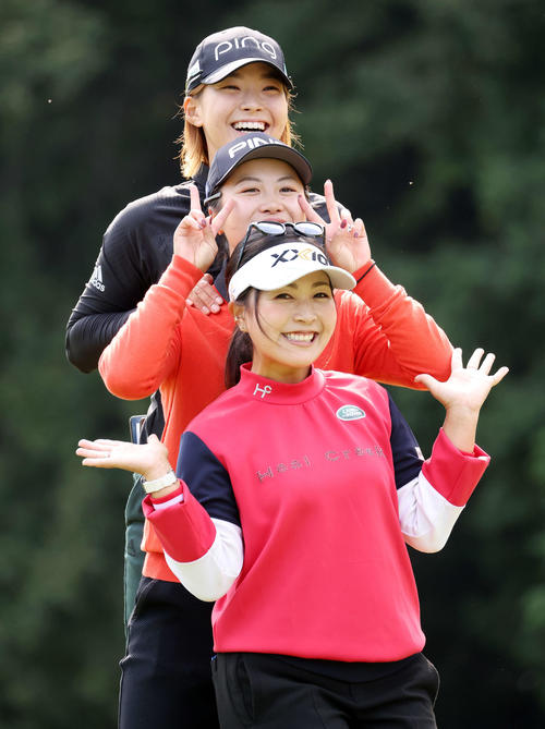 9番ティーで、笑顔でトーテムポールのようなポーズをとる渋野（上）、上野（中央）、青木（撮影・浅見桂子）