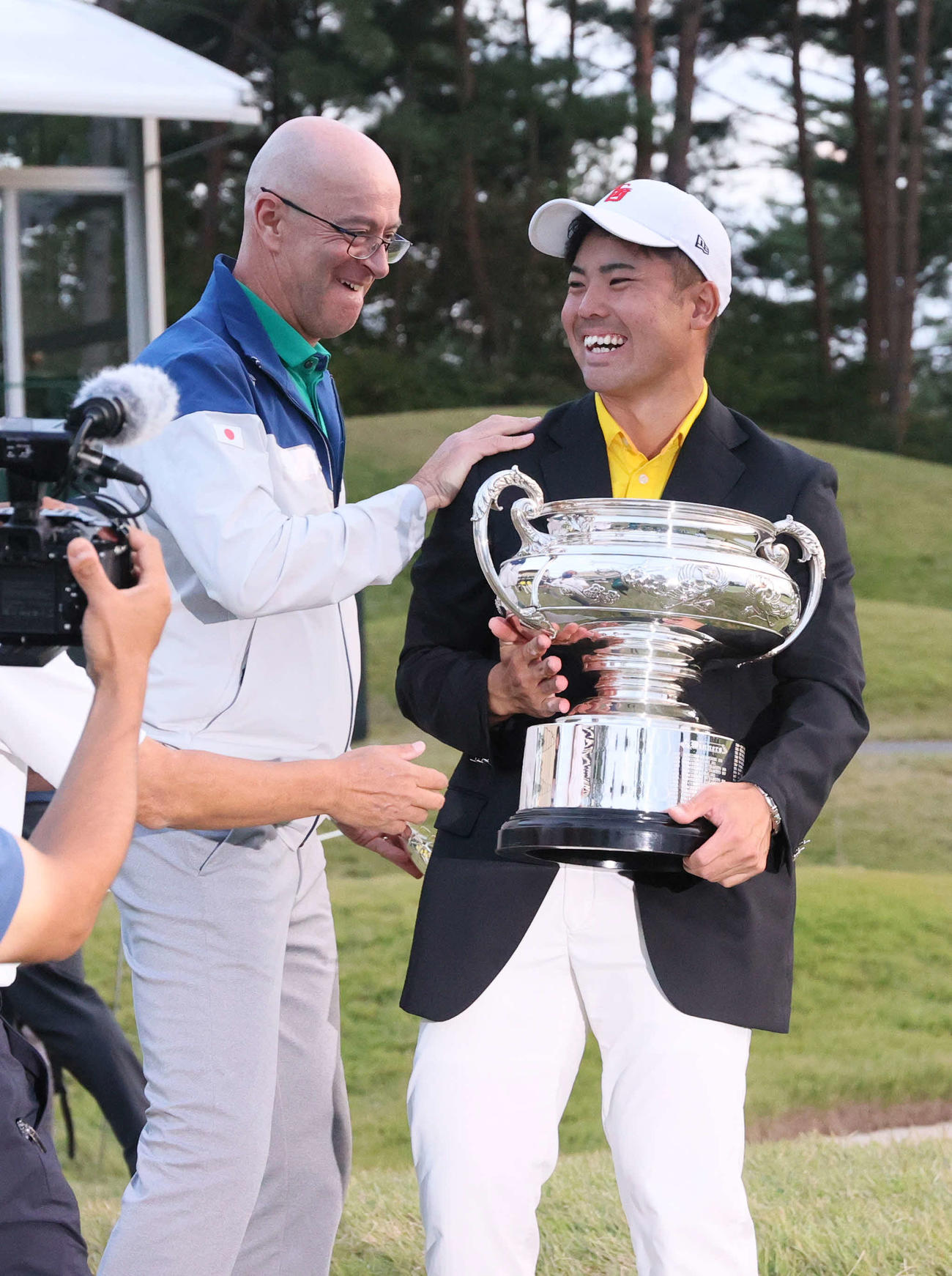 優勝の蝉川（右）を祝福するJGAナショナルチームのガレス・ジョーンズヘッドコーチ（撮影・上山淳一）