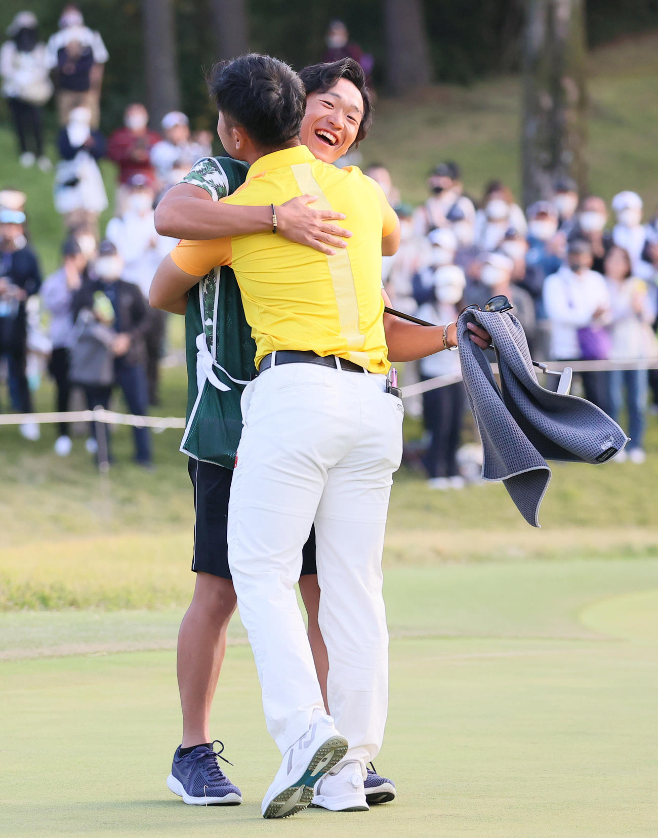 優勝を決めた蝉川（手前）と抱き合って喜ぶ石過キャディー（撮影・上山淳一）