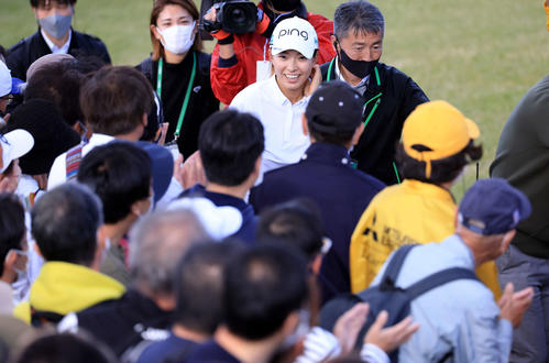 ホールアウトした渋野（中央）はギャラリーの拍手の中、笑顔で引き揚げる（撮影・浅見桂子）