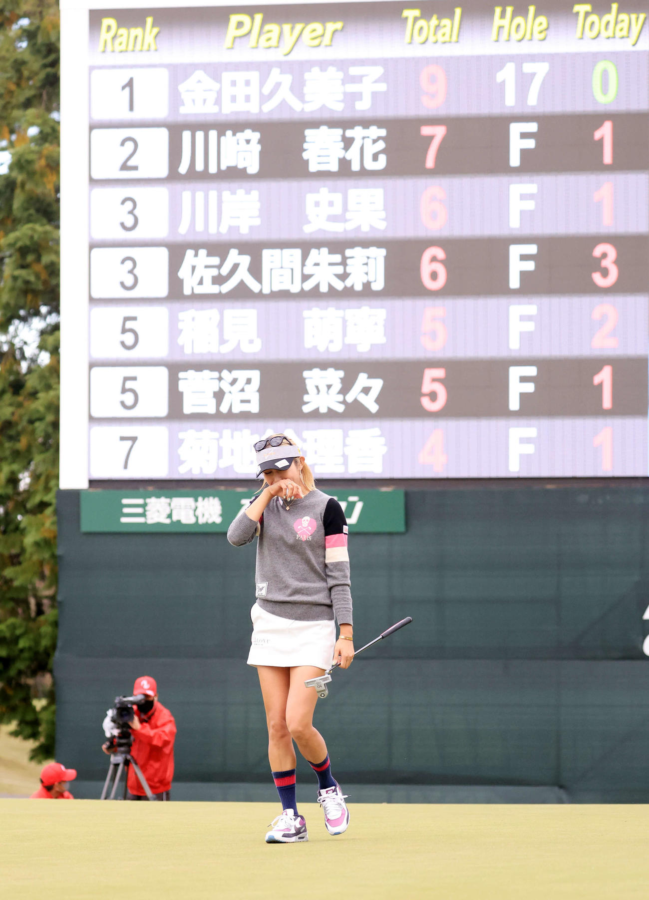 18番、ウイニングパットを沈めて11年ぶりの優勝を決めた金田はスコアボードを背に涙をこらえる（撮影・浅見桂子）