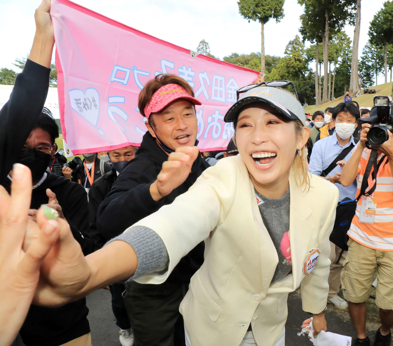 18番、11年ぶりの優勝を決めた金田は、横断幕を掲げる応援団と笑顔で喜び合う（撮影・浅見桂子）