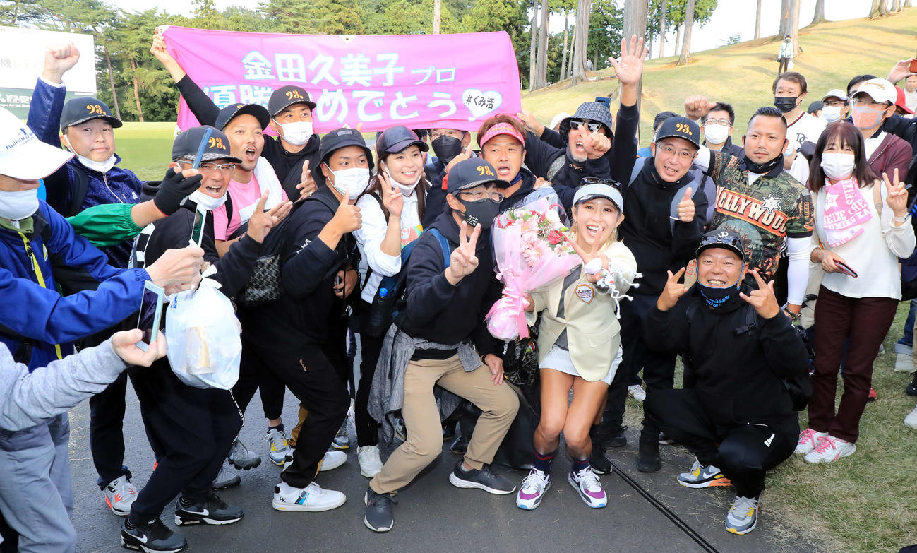 18番、11年ぶりの優勝を決めた金田は、横断幕を掲げる応援団と笑顔で記念撮影（撮影・浅見桂子）