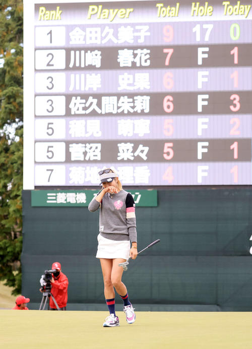 18番、ウイニングパットを沈めて11年ぶりの優勝を決めた金田はスコアボードを背に涙をこらえる（撮影・浅見桂子）