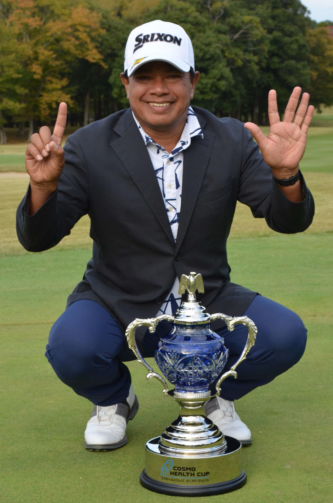 優勝杯を置き、両手で連勝数の「6」を作るプラヤド・マークセン（撮影・吉池彰）
