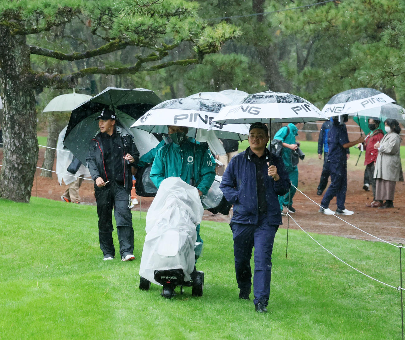 1番を終えたところで降雨中断のホイッスルが鳴りクラブハウスへ引き揚げる大岩（右）と木下ら（撮影・加藤哉）
