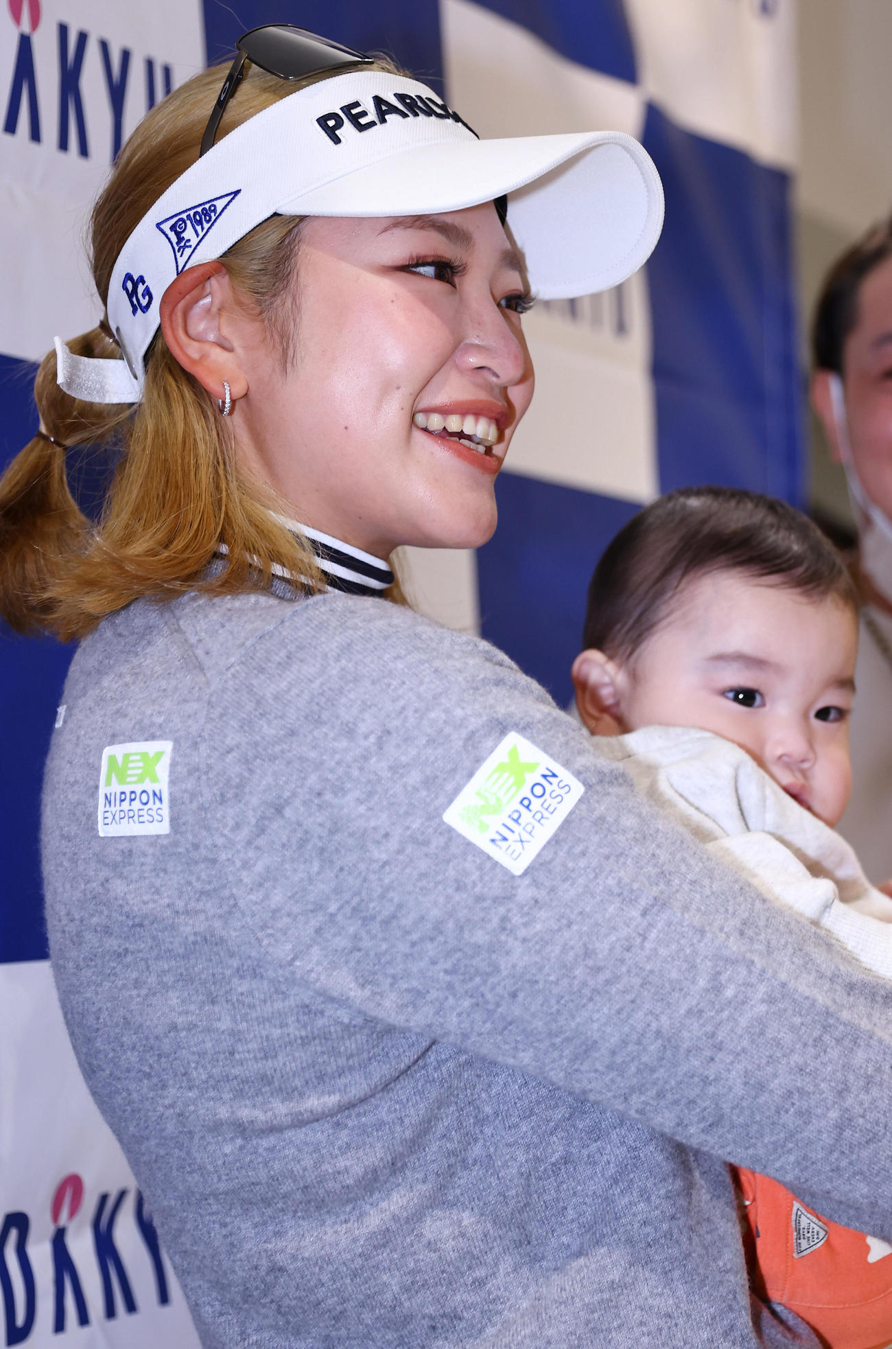 サイン会でファンの子どもを抱っこして笑顔を見せる原（撮影・垰建太）