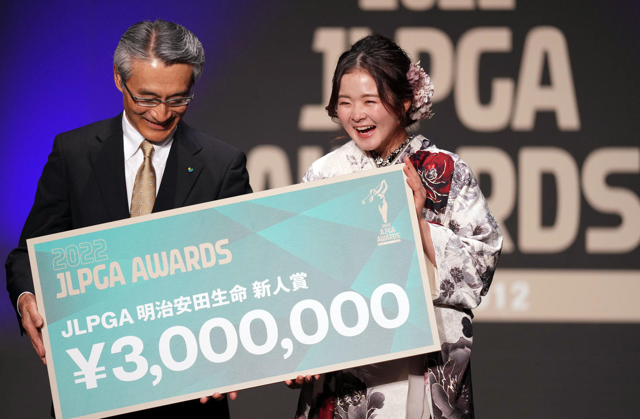 JLPGAアワード明治安田生命新人賞を受賞し、賞金ボードを手に笑顔を見せる川崎（右）（撮影・狩俣裕三）