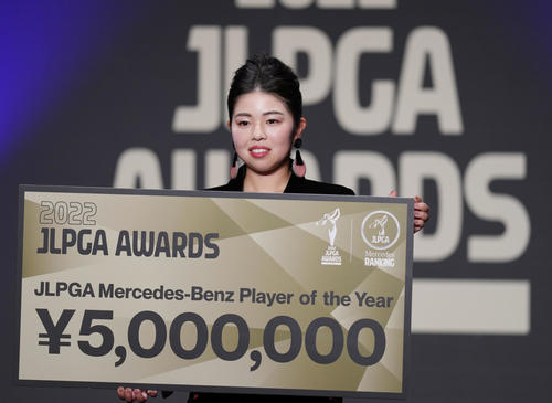 JLPGAアワードで年間最優秀選手に選ばれ、賞金ボードを手に笑顔を見せる山下（撮影・狩俣裕三）