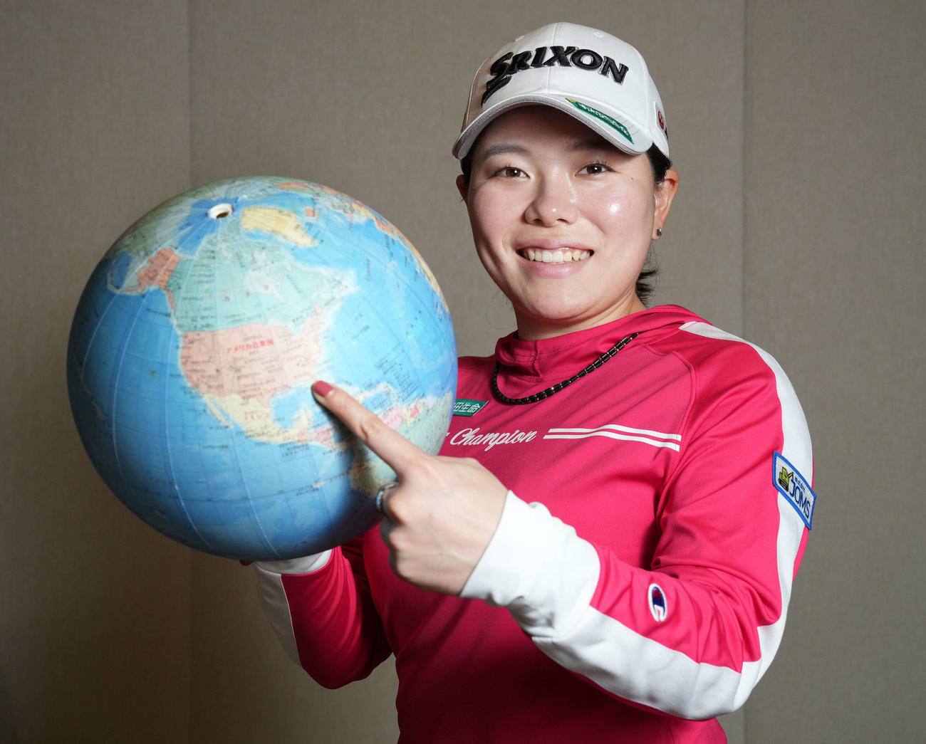 米女子ゴルフツアーに本格参戦する勝は、地球儀の米国を笑顔で指さす（撮影・鈴木みどり）