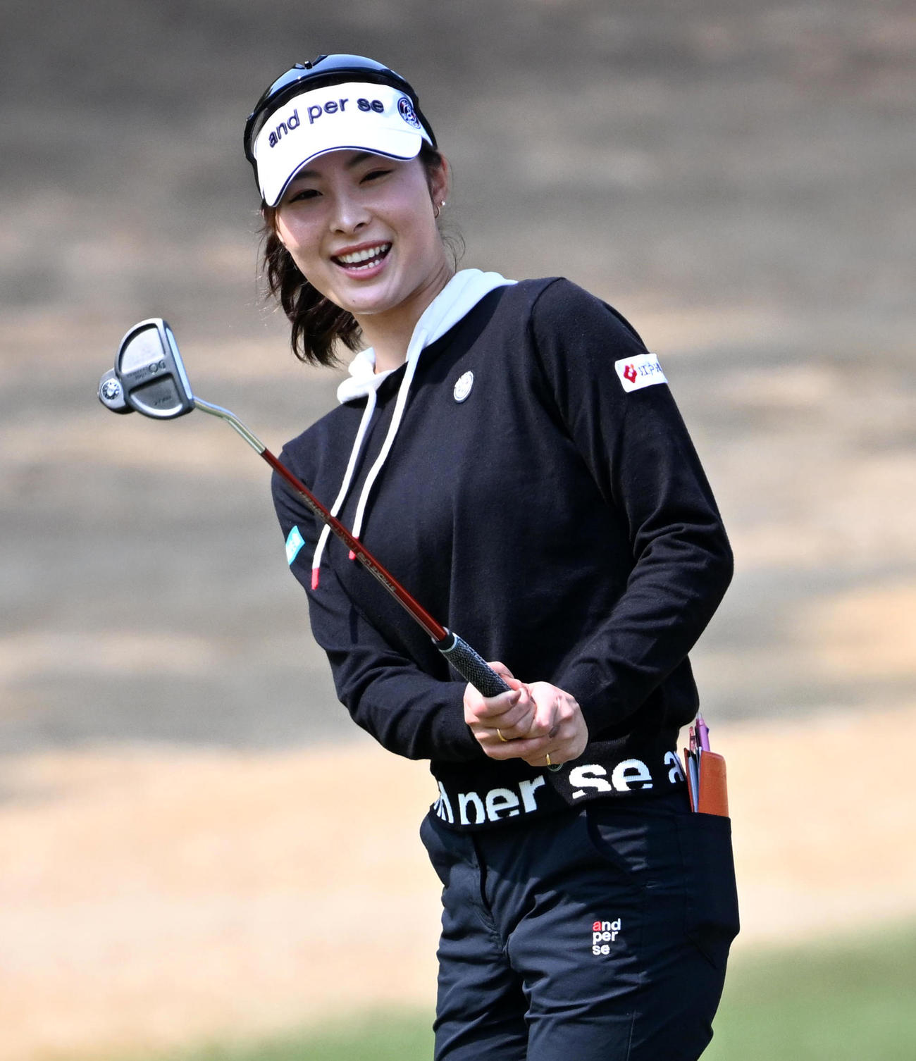 9番、グリーンで笑顔を見せる鶴岡（撮影・前岡正明）