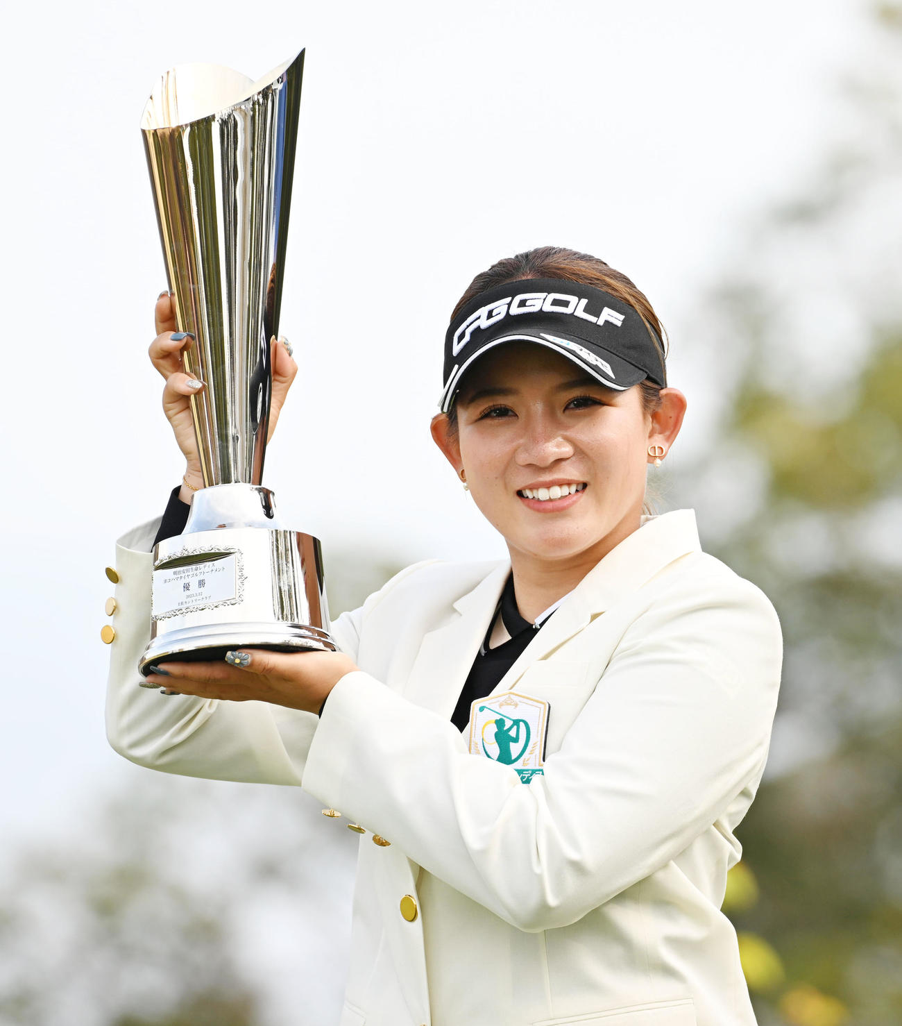 優勝カップを手に笑顔を見せる吉本（撮影・前岡正明）