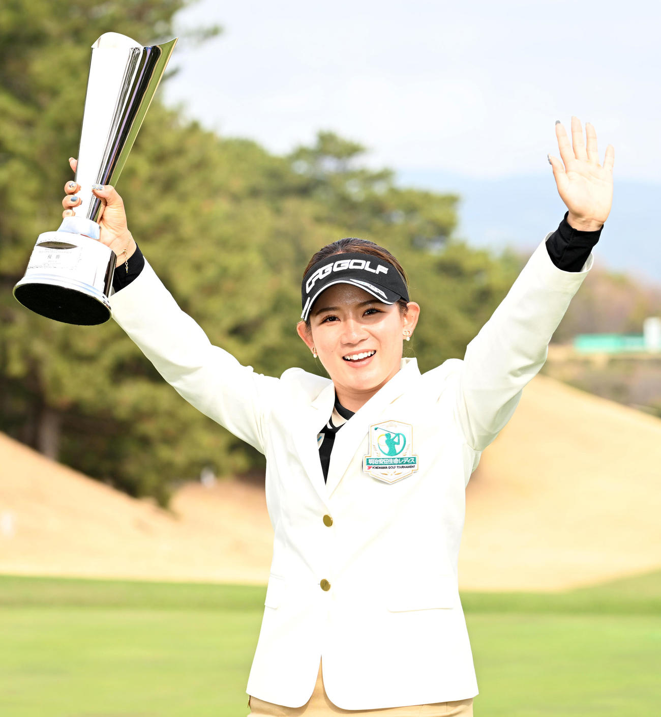 優勝カップを手にバンザイをする吉本（撮影・前岡正明）