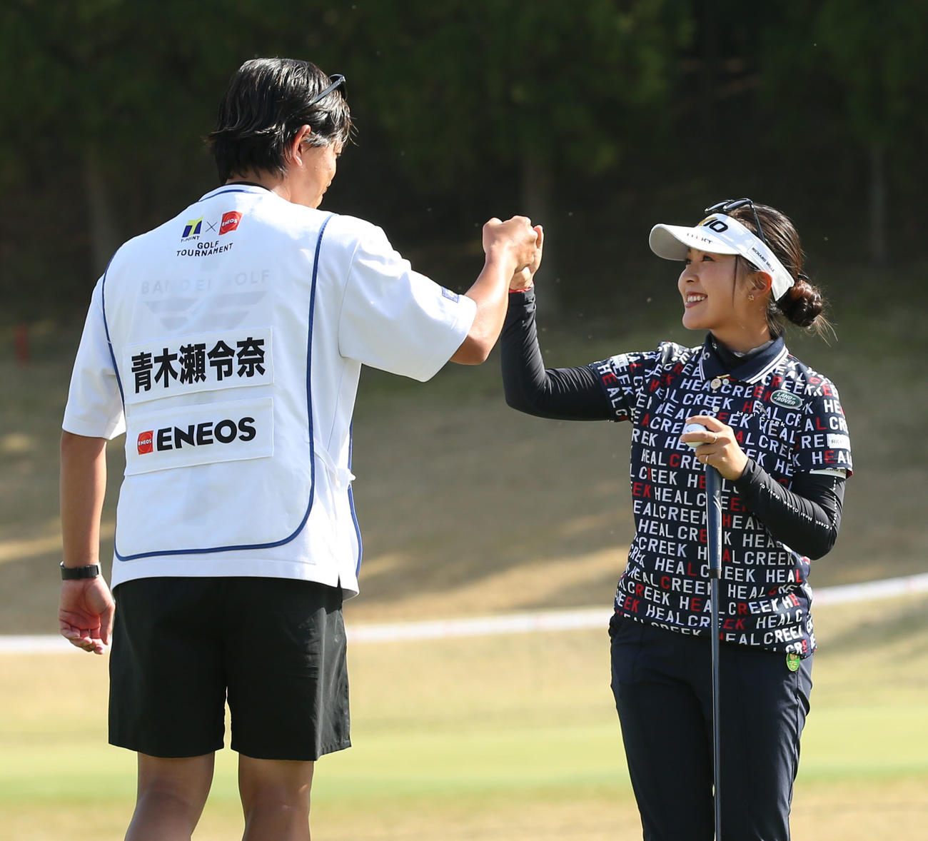 優勝を決め、キャディーとグータッチを交わす青木（撮影・屋方直哉）