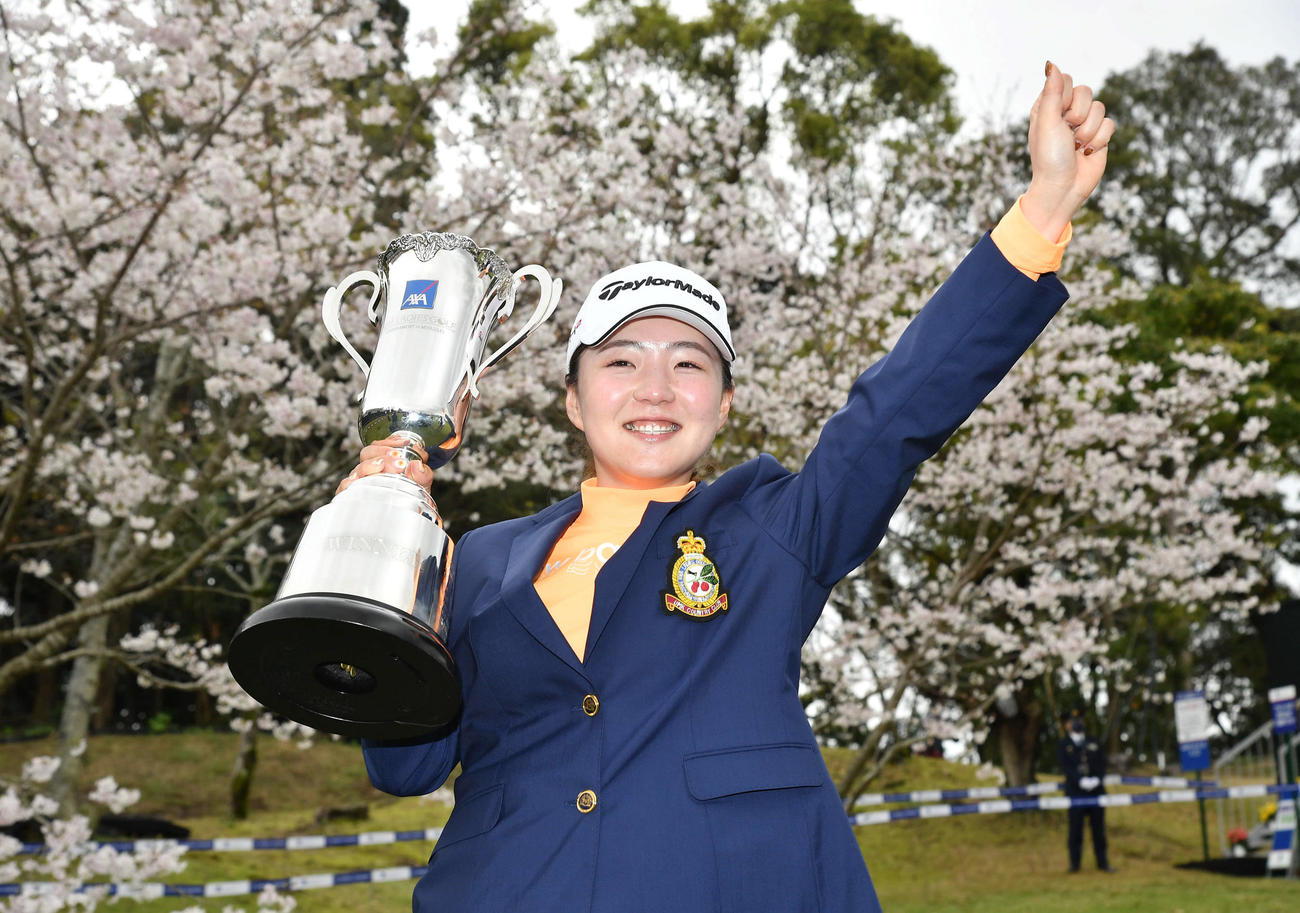 ツアー初優勝の山内日菜子は、桜をバックに笑顔でガッツポーズ（撮影・岩下翔太）
