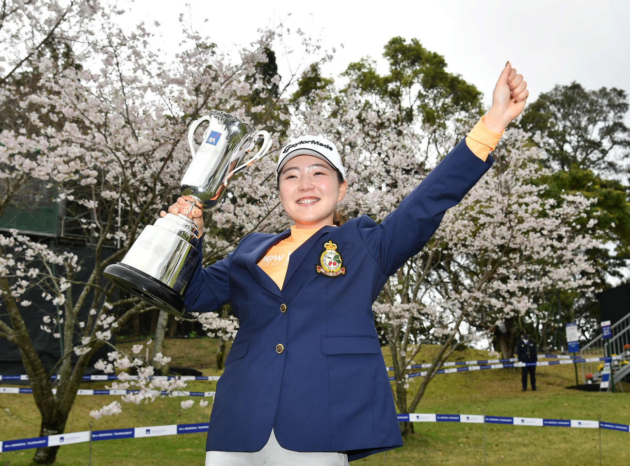 ツアー初優勝の山内日菜子は、桜をバックに笑顔でガッツポーズ（撮影・岩下翔太）