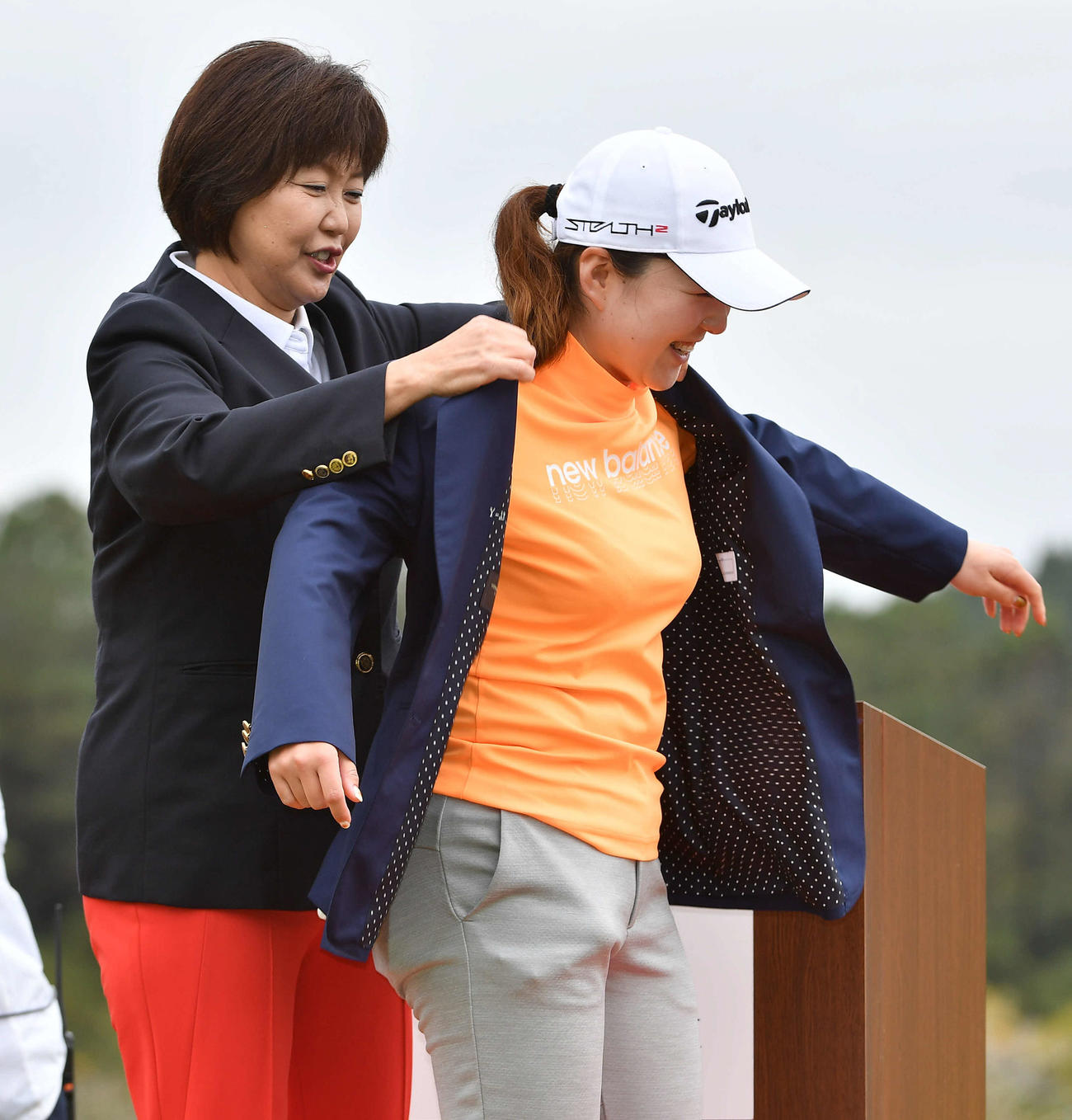アクサレディス宮崎最終日　表彰式でJLPGA小林浩美会長（左）からウイニングジャケットを着せてもらう山内日菜子（撮影・岩下翔太）