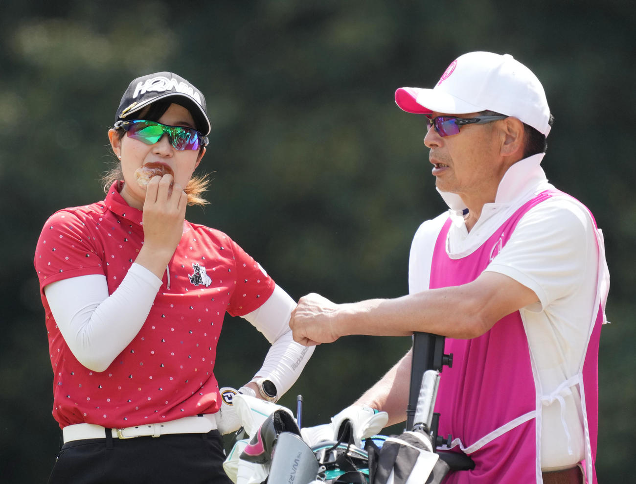 5番、おにぎりを食べながら、キャディーの父宏さん（右）と話をする蛭田（撮影・狩俣裕三）