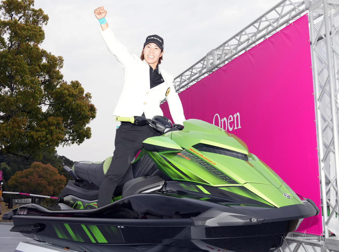 優勝し、副賞の水上バイクにまたがり記念撮影する穴井（撮影・狩俣裕三）