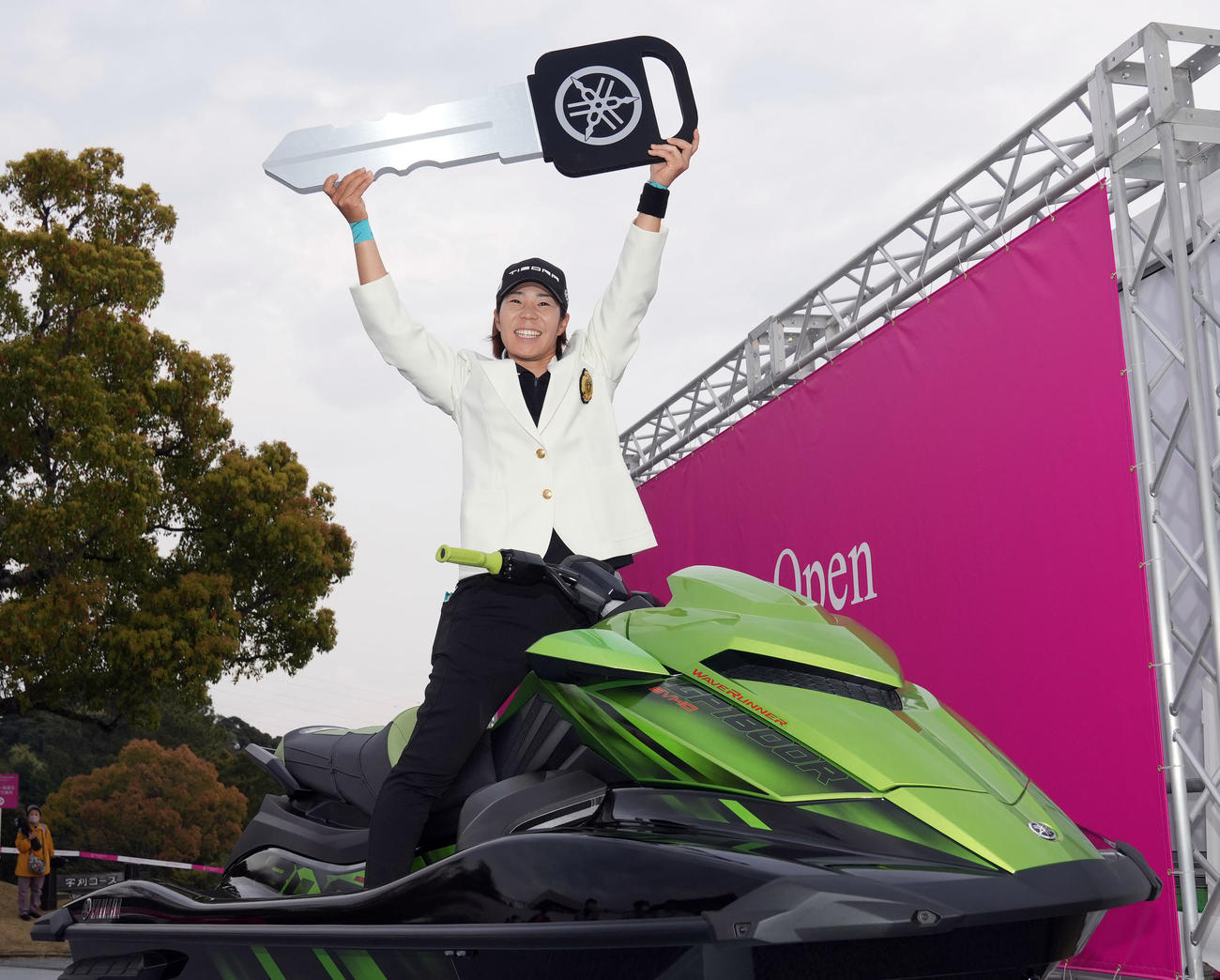 優勝し、副賞の水上バイクにまたがり記念撮影する穴井（撮影・狩俣裕三）