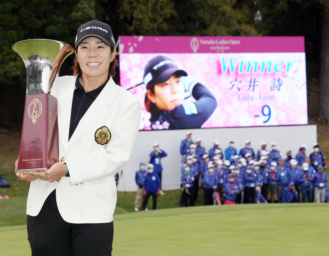 優勝し、カップを手に記念撮影する穴井（撮影・狩俣裕三）