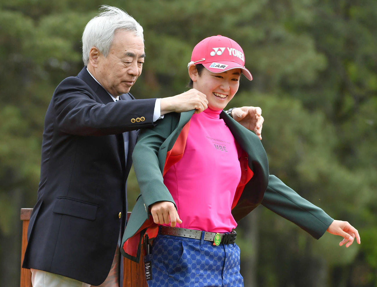 KKT杯バンテリン・レディース最終日　優勝した岩井明愛は、グリーンジャケットを着せてもらい笑顔を見せる（撮影・岩下翔太）
