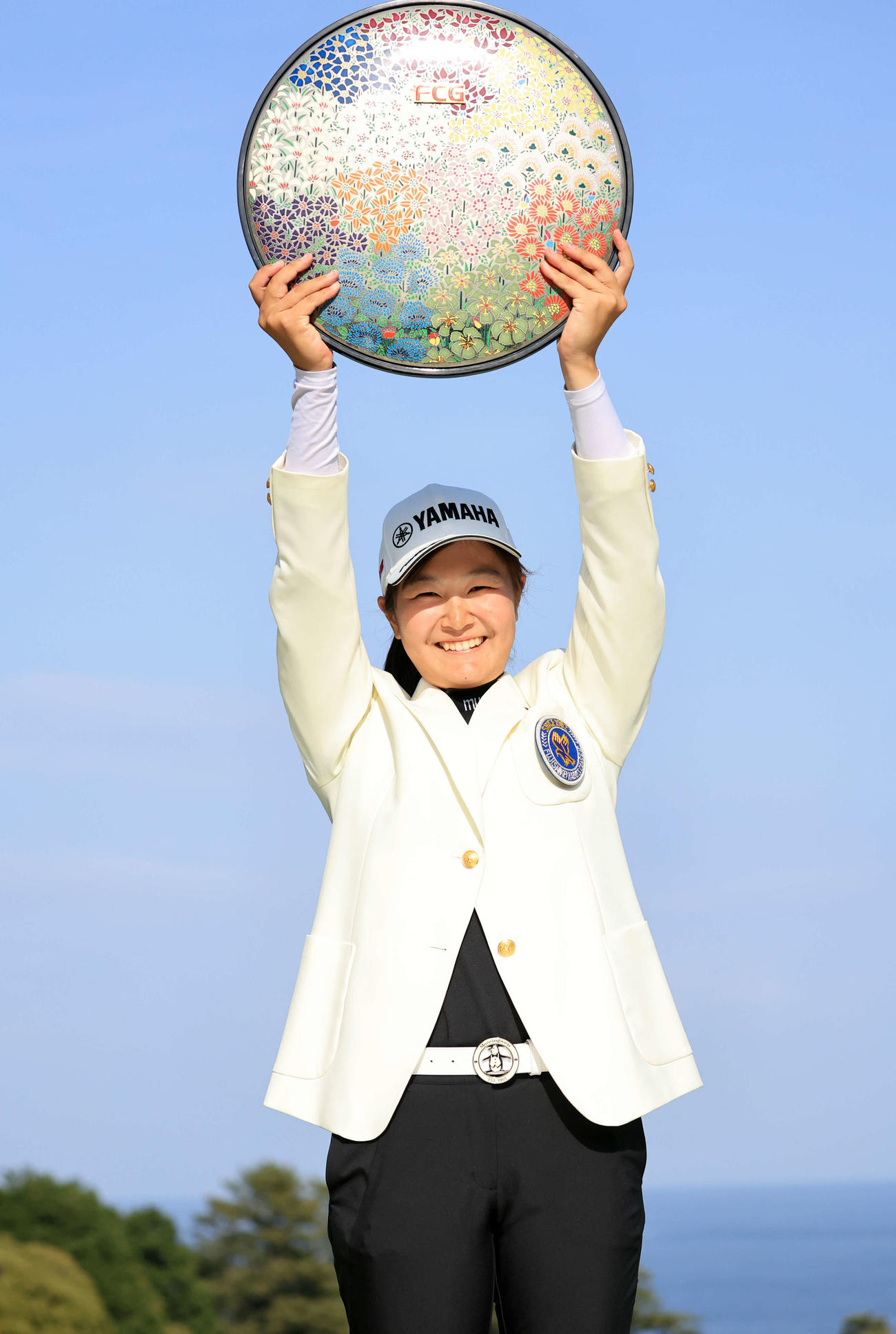 初優勝の神谷は青空のした笑顔で優勝杯を掲げる（撮影・浅見桂子）