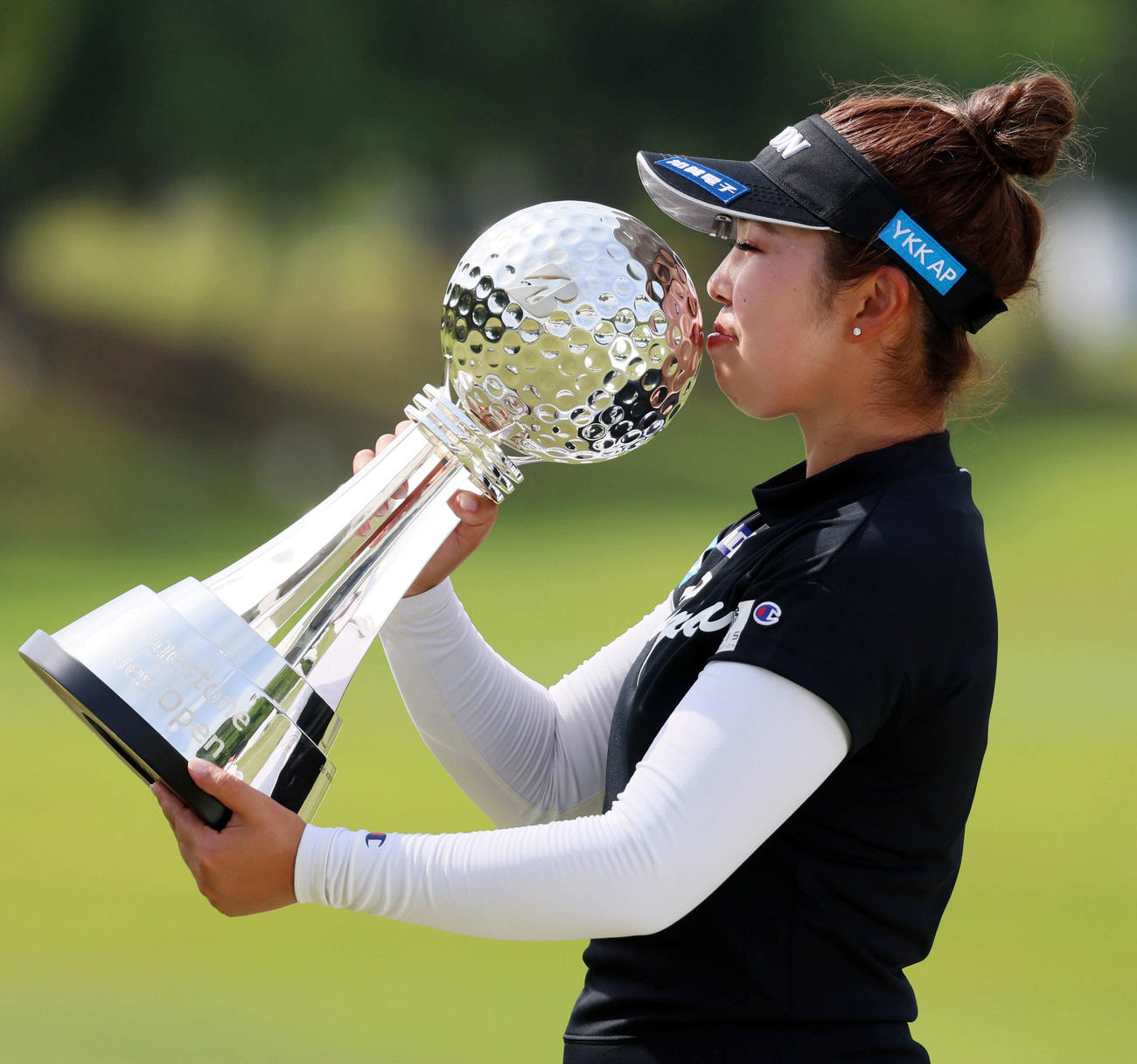 18アンダーで優勝し、ブリヂストン杯にキスする山下美夢有（撮影・加藤哉）