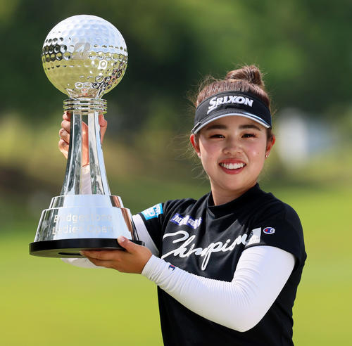 18アンダーで優勝し、ブリヂストン杯を持つ山下美夢有（撮影・加藤哉）