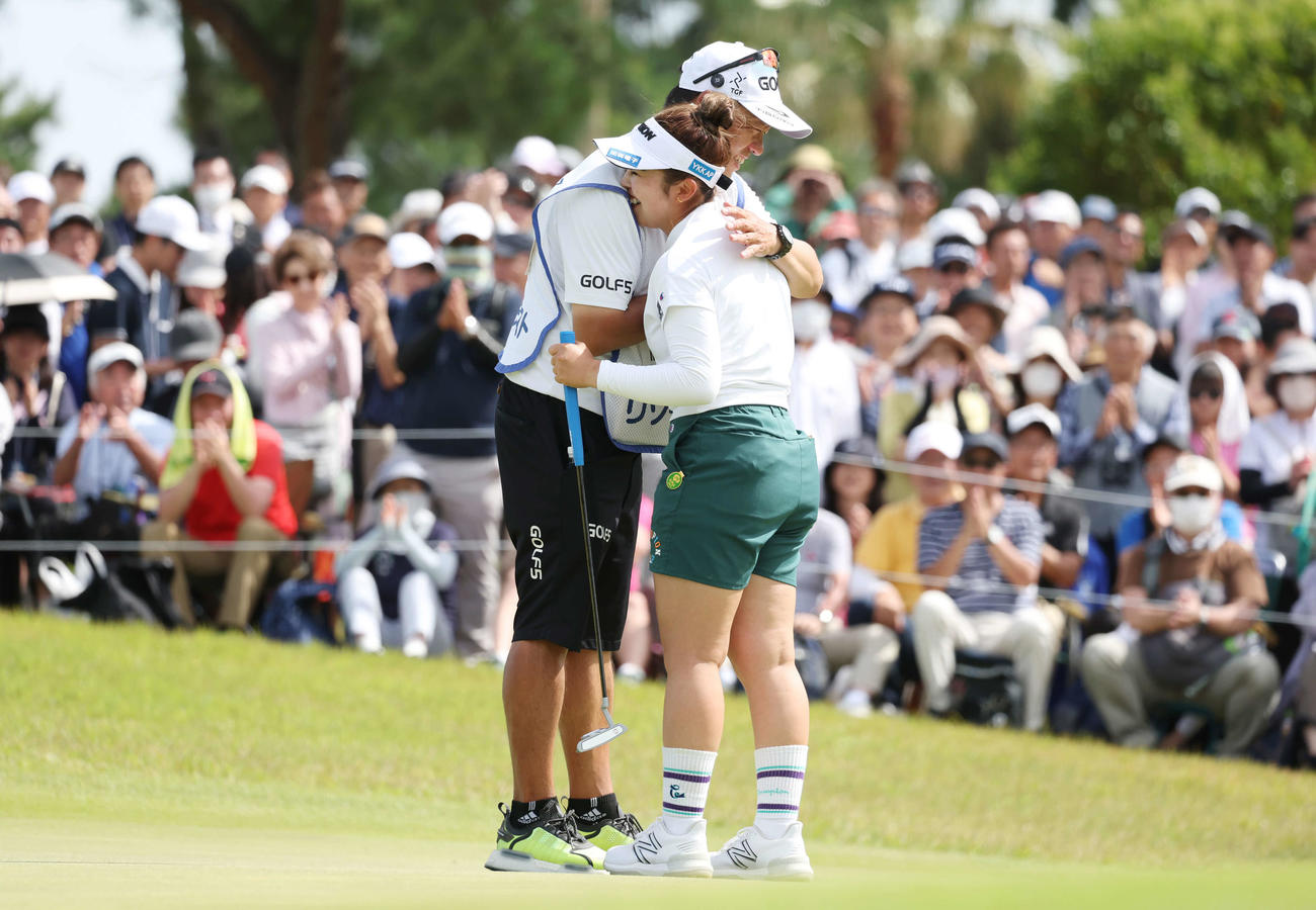 優勝を決め、キャディーと笑顔で抱擁を交わす山下（撮影・宮地輝）