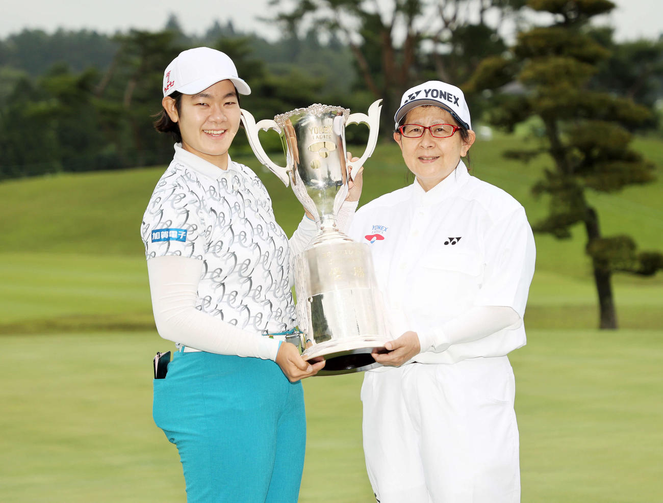 優勝トロフィーを手に笑顔を見せる川岸（左）とキャディーを務めた母の麻子さん（撮影・鈴木正人）