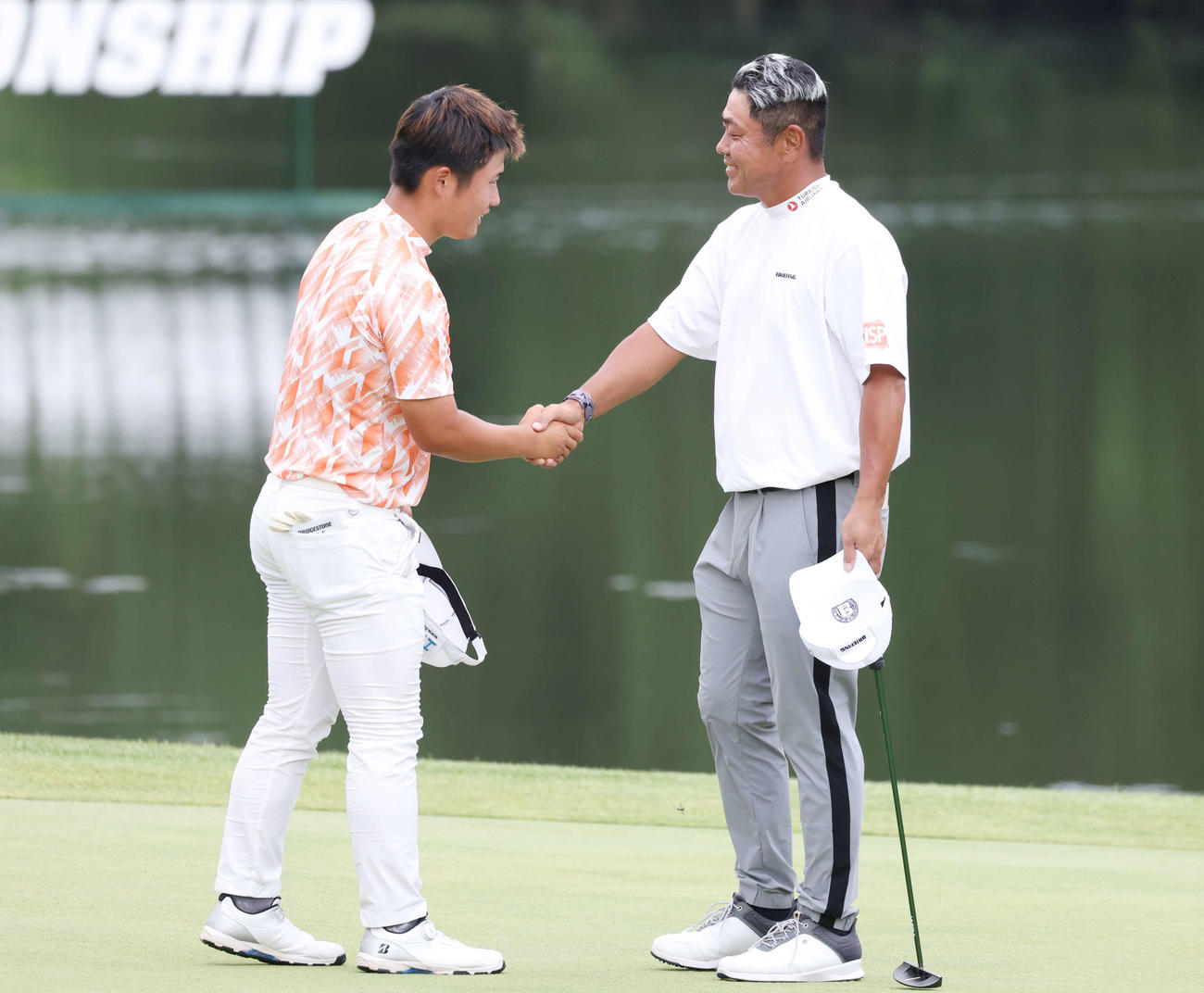 プレーオフを制して優勝し、長野（左）と握手する谷原（撮影・宮地輝）