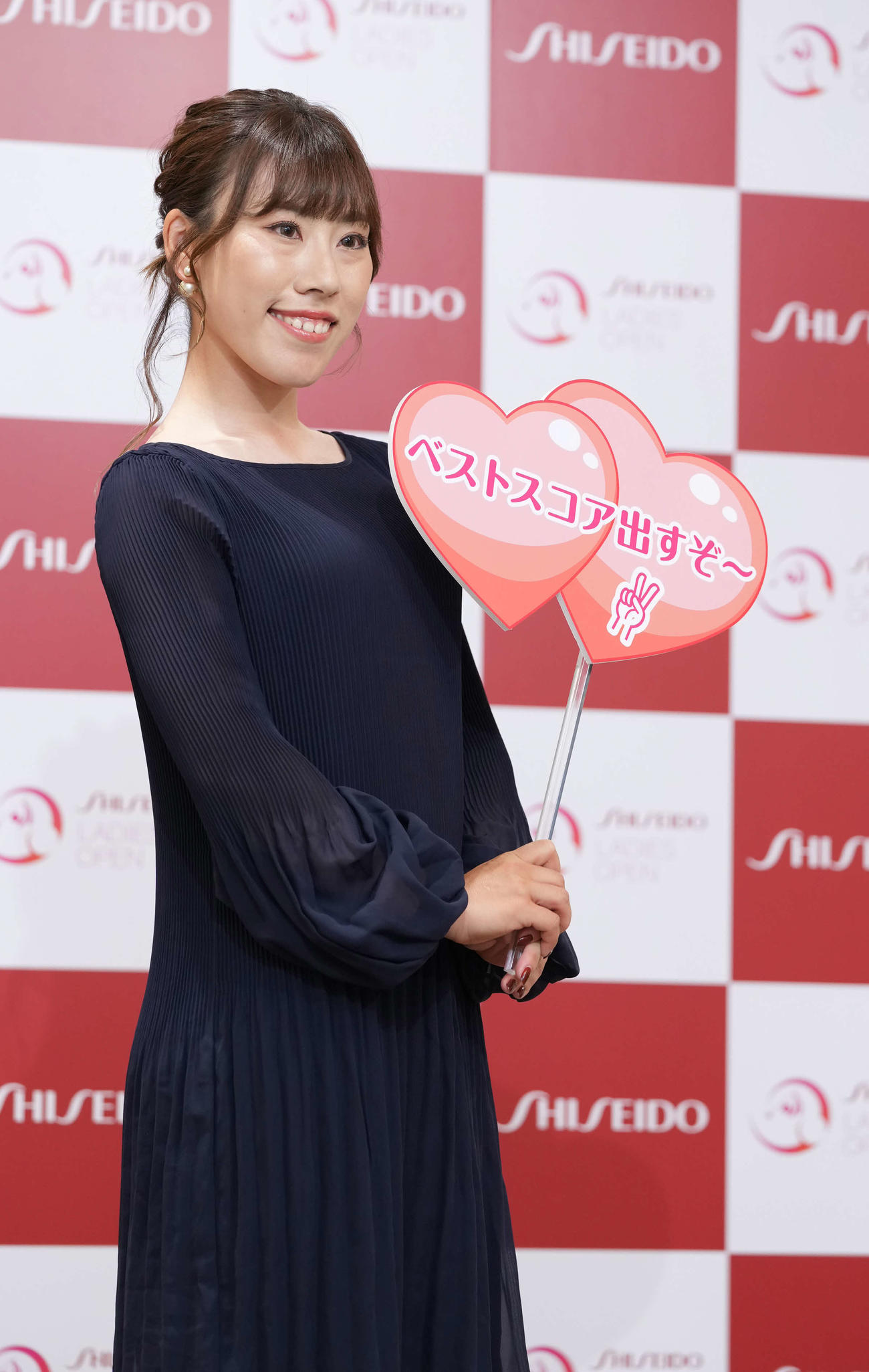 資生堂レディースオープンの前夜祭で華やかにドレスアップした衣装でメッセージボードを手にする木村彩子（撮影・小沢裕）
