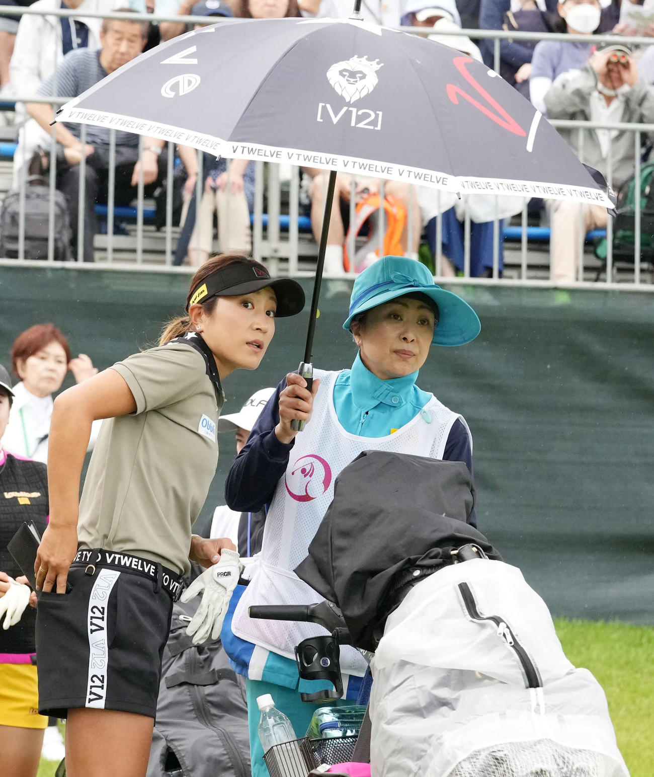 1番、スタート前にキャディーといっしょに傘に入る藤本（撮影・小沢裕）