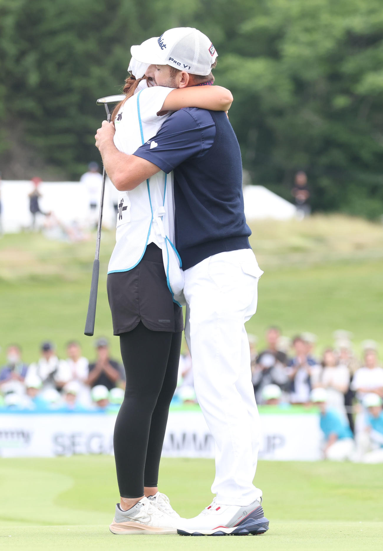 優勝しキャディーを務めた妻のデニスさんと抱き合って喜ぶクルーガー（撮影・佐藤翔太）