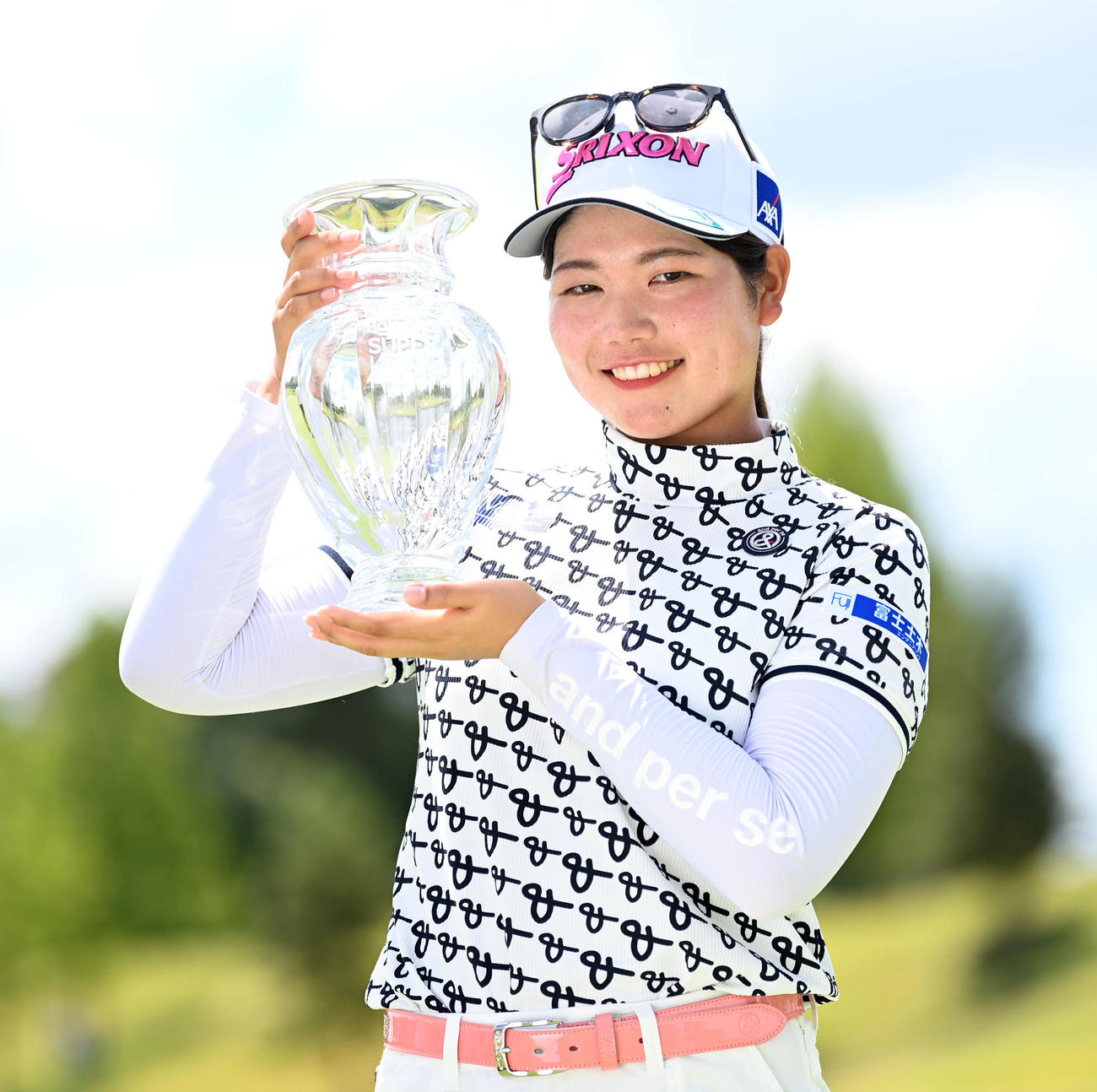 通算21アンダーで優勝、優勝杯を手に笑顔を見せる桜井（撮影・前岡正明）