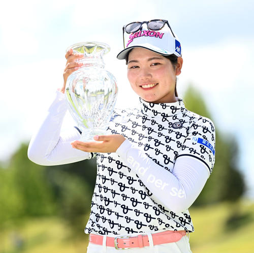 通算21アンダーで優勝、優勝杯を手に笑顔を見せる桜井（撮影・前岡正明）