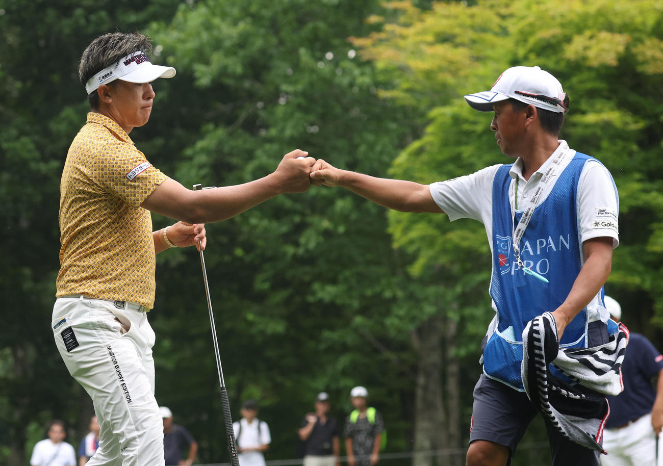 9番、バーディーパットを沈めキャディーとグータッチをする上井（撮影・佐藤翔太）