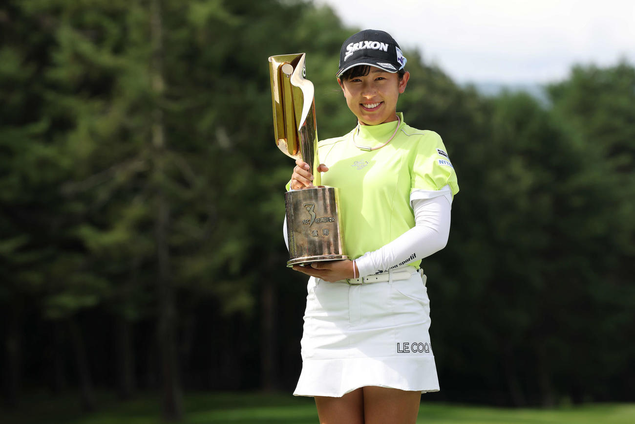 優勝トロフィーを手に笑顔で写真に納まる菅沼（撮影・河田真司）