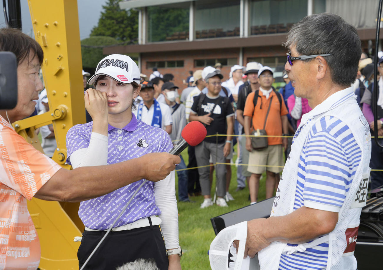 優勝インタビューで涙を流す蛭田みな美（中央）。右はキャディーを務めた父親の宏さん（共同）