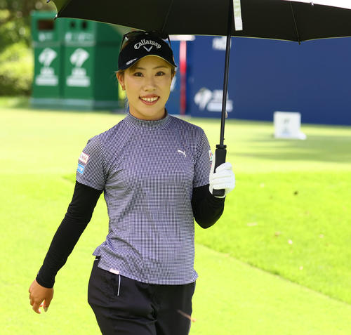 1番　日傘を手に移動する木村彩子（撮影・冨田成美）